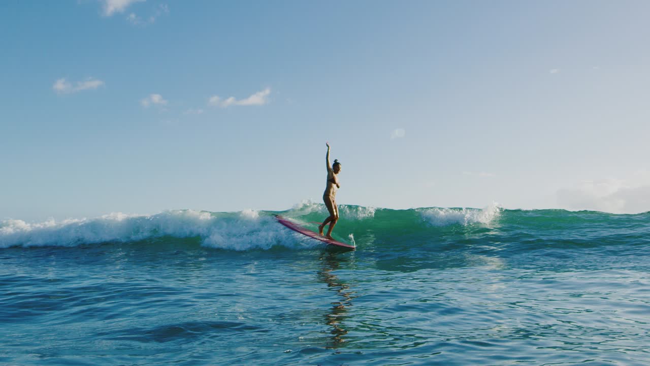 una mujer joven surfeando al atardecer.