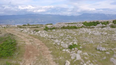 fast and low aerial flyover of the moon plateau on krk island, croatia on a cloudy day