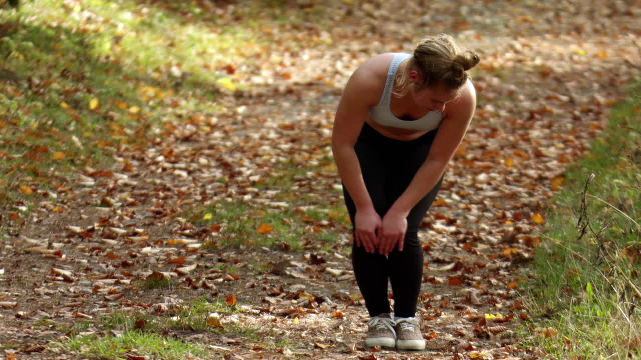 Sexy sport girl warming up her knees before jogging,wide shot