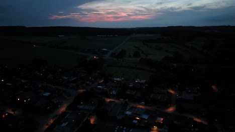 slow flight over american neighborhood. aerial wide shot. quiet scene with warm lighting lantern. dusk or night scene. houses and homes in american suburb.