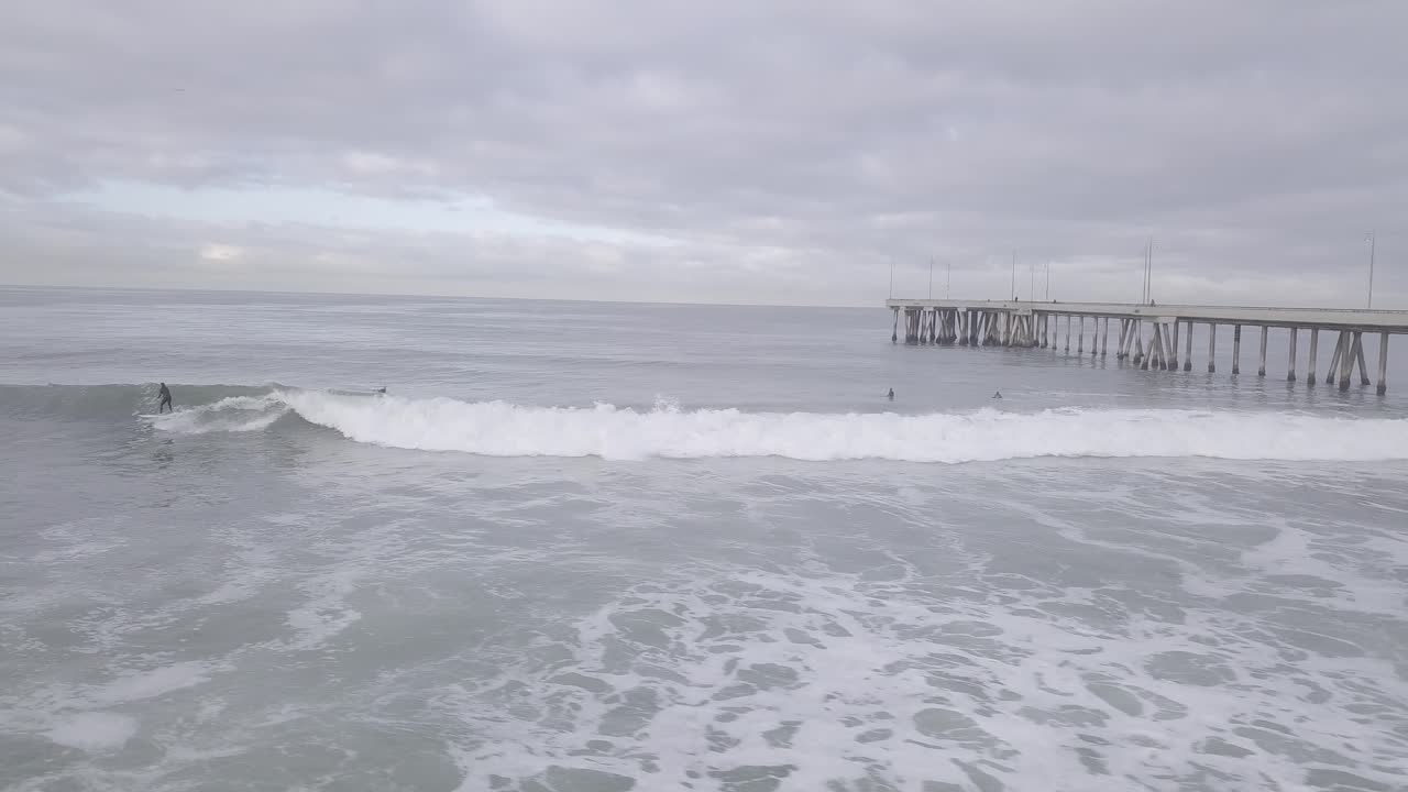 서퍼는 아침에 베니스 부두에서 파도를 잡는다