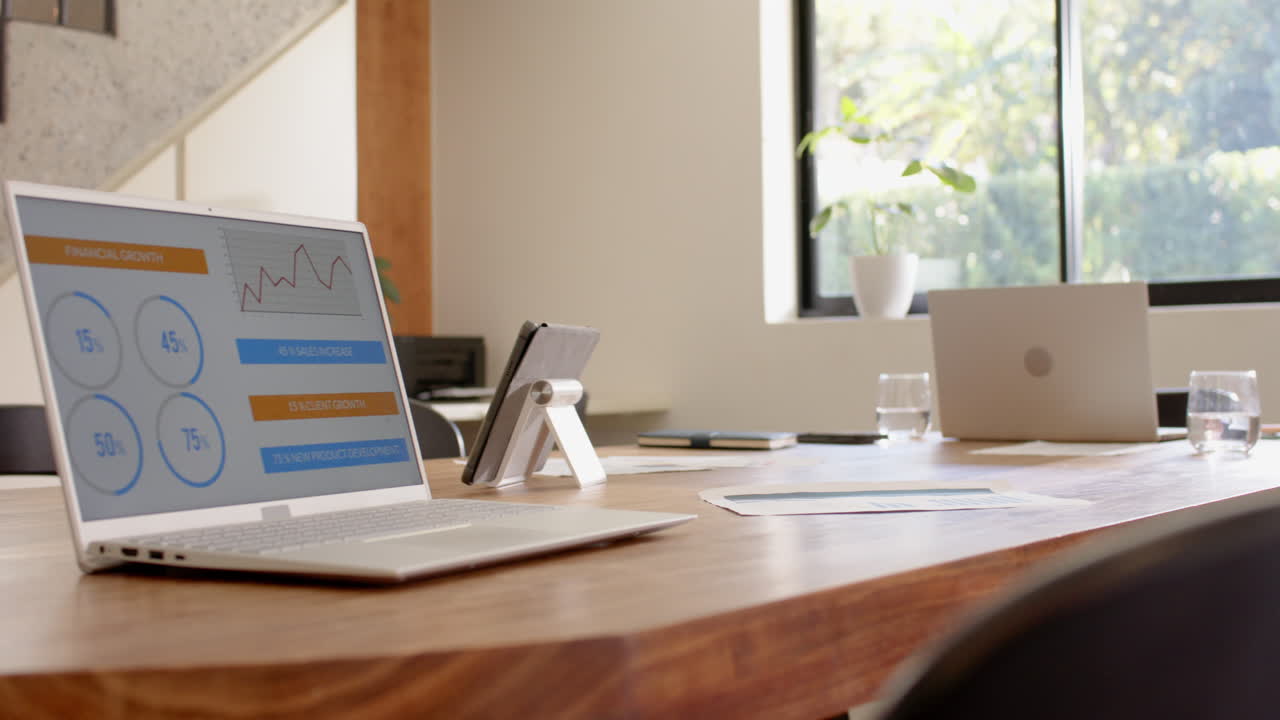 Laptops on wooden table with financial graphs, preparing for business meeting