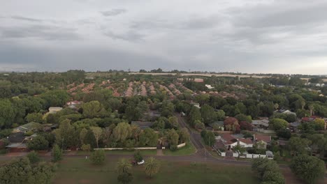 Vuelo-Aéreo-De-Drones-4k-Sobre-Una-Zona-Residencial-Con-Un-Puente-De-Tren-En-El-Fondo-Distante-En-Sudáfrica