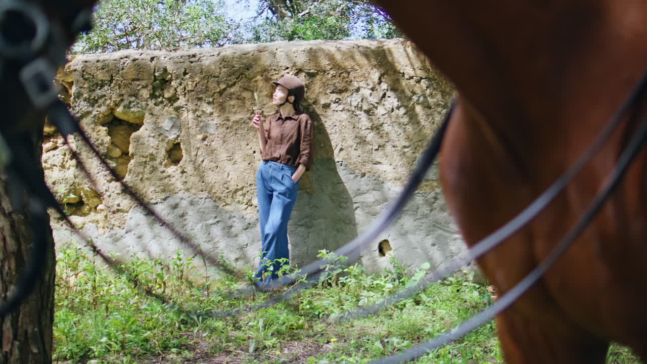 Woman jockey resting nature leaning wall outdoor. mare walking field