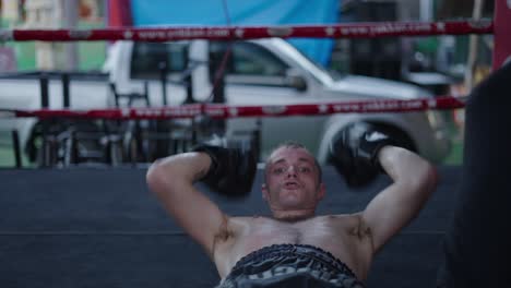 man performing sit-ups during intense boxing training