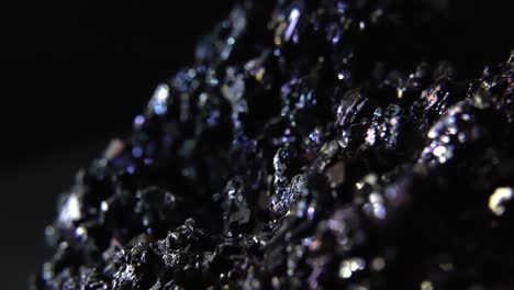 glowing gemstones in solid dark rock piece isolated on black background