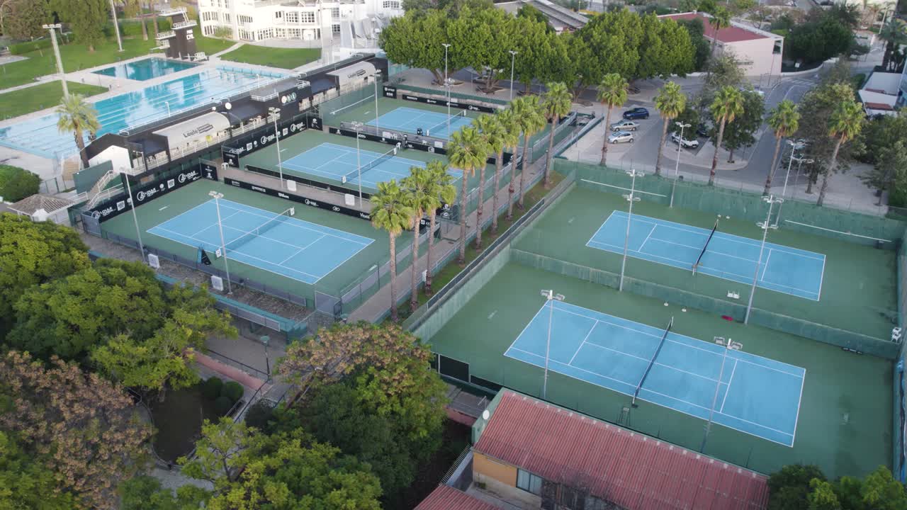 Veduta aerea di campi da tennis all'aperto e piscina in un complesso sportivo