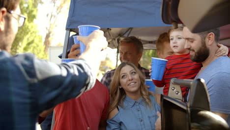 slow motion shot of sports fans tailgating in parking lot