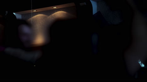 blurred silhouettes moving rhythmically across dimly lit nightclub dance floor, capturing energetic nightlife with anonymous dancers creating vibrant, pulsing atmosphere of youth and joy