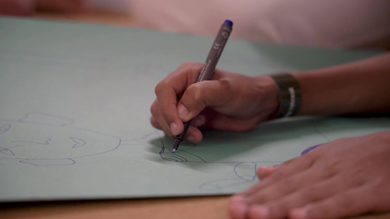 Close-up footage of a person drawing and sketching on paper with a pen. Creative process imagery suitable for design, illustration, education, brainstorming, writing and artistic concepts.