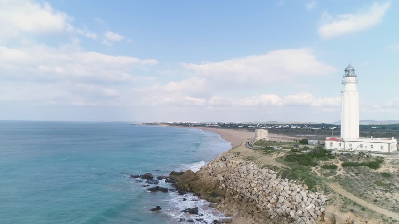 화창한 날 잔잔한 바다 옆에 있는 하얀 등대의 공중 전망