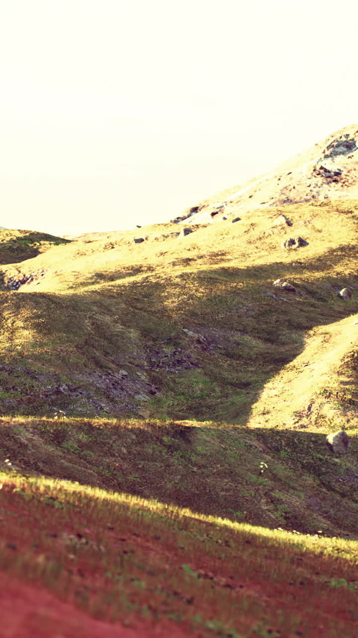 paisaje montañoso pintoresco con colinas cubiertas de hierba y un pico cubierto de nieve