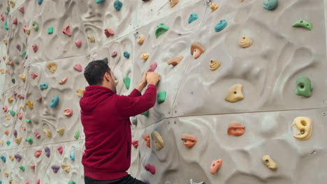 man climber climbs a climbing wall without insurance in outdoor sport ground