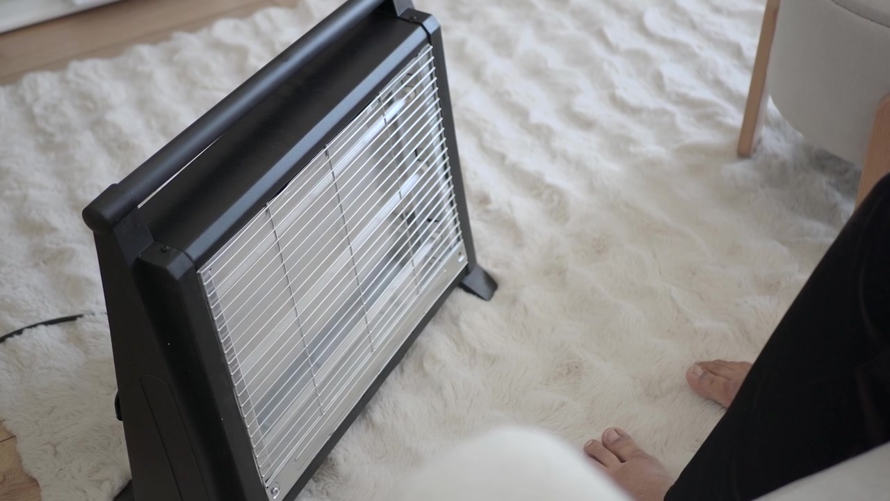 Person varmer fødder foran elradiator