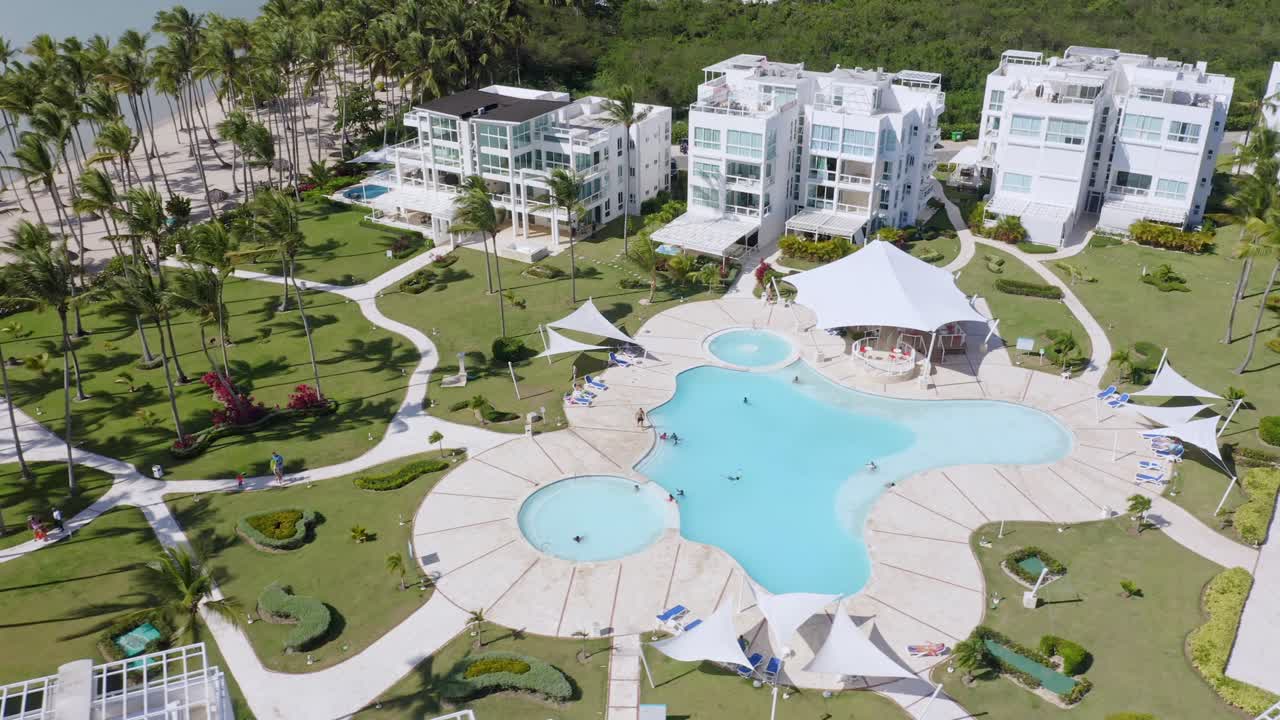 사람들은 도미니카 공화국의 여름 동안 la ensenada playa nueva romana의 수영장에서 수영합니다.