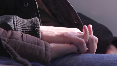 Woman-and-man-holding-hands-on-a-train