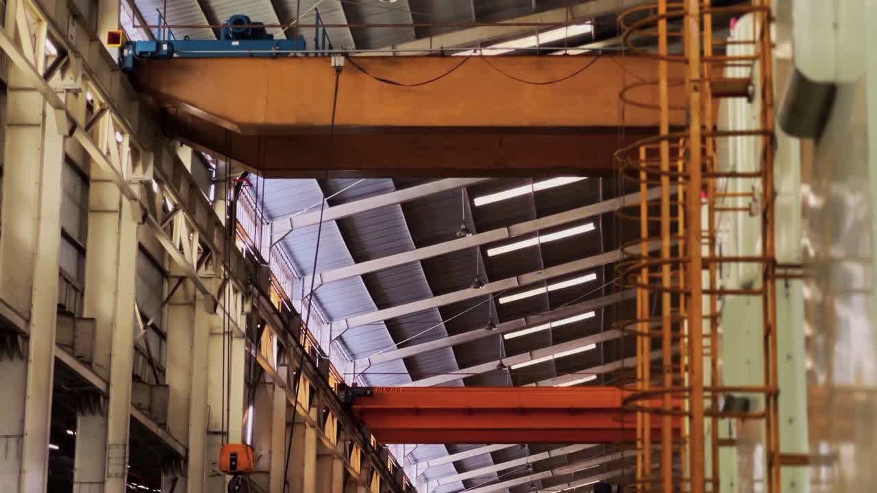 escalera para subir a una máquina grande en el área de producción de la fábrica con vistas a mover la grúa aérea