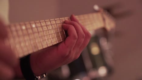 narrow focus: musician plays maple neck electric guitar, close up
