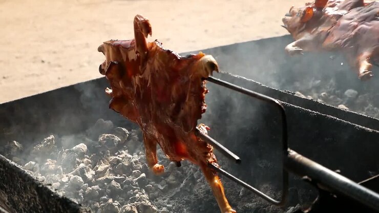 La cottura di un maiale intero arrosto su griglia a carbone