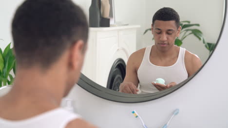 hombre negro guapo aplicando espuma de afeitar