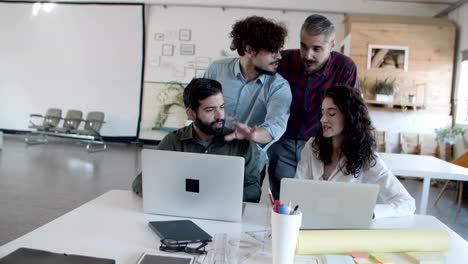 Bearded-curly-young-manager-talking-to-subordinates