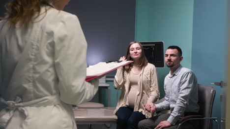 gynecologist approaches her pregnant patient and her husband in the medical consultation and informs them of the results of the ultrasound