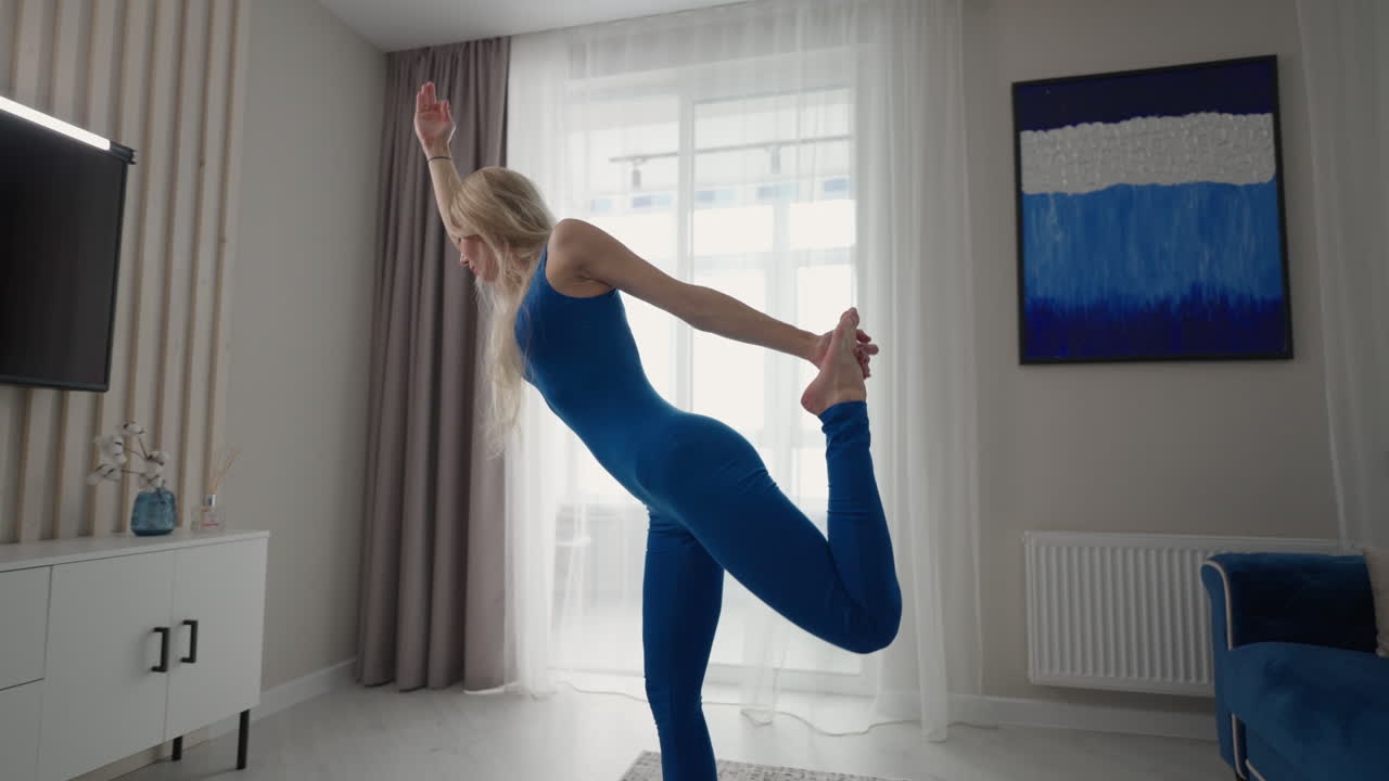 permaneciendo en casa en cuarentena y trabajando remotamente desde casa una mujer entrena y hace ejercicios de equilibrio mientras está de pie en la alfombra. ropa deportiva haciendo ejercicio quemando grasas calorías entrenamiento de fuerza