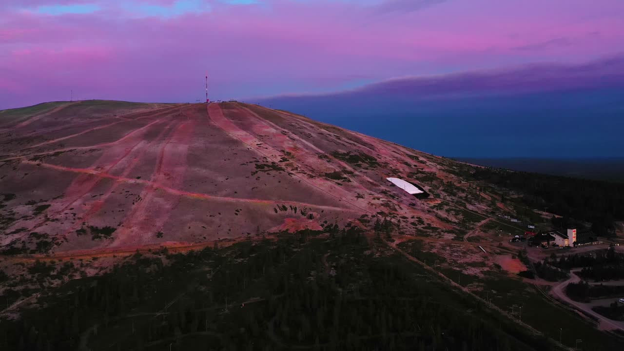 Aerial view of the Yllas fell and ski resort, on a colorful, summer dusk, during midnight sun, in Pallas-Yllastunturi national park, Kolari, Lapland, Finland - tracking, drone shot