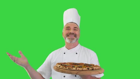 chef sonriente olor a pizza deliciosa y haciendo gesto de mermelada real en una pantalla verde, llave de croma