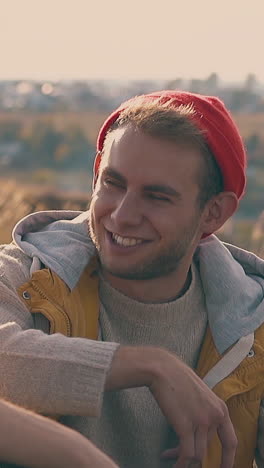 happy young hiker talks to boyfriend in red hat resting near tent on autumn meadow at sunrise slow motion