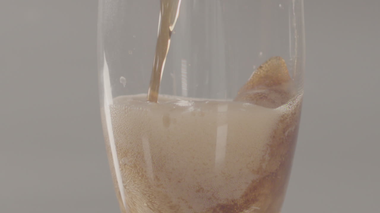 콜라가 유리 개에 부어지고 표면으로 올라갑니다 - 240fps 느린 동작