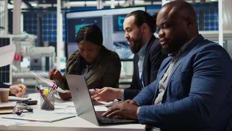 factory manager developing business model using laptop, expanding production