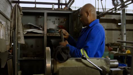 metalsmith looking at tools in cupboard 4k