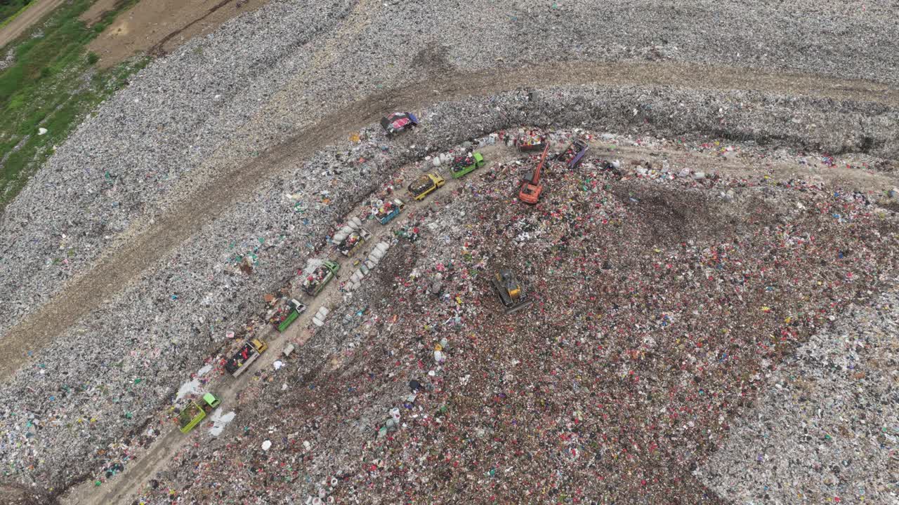 Aerial view of garbage trucks at a landfill site