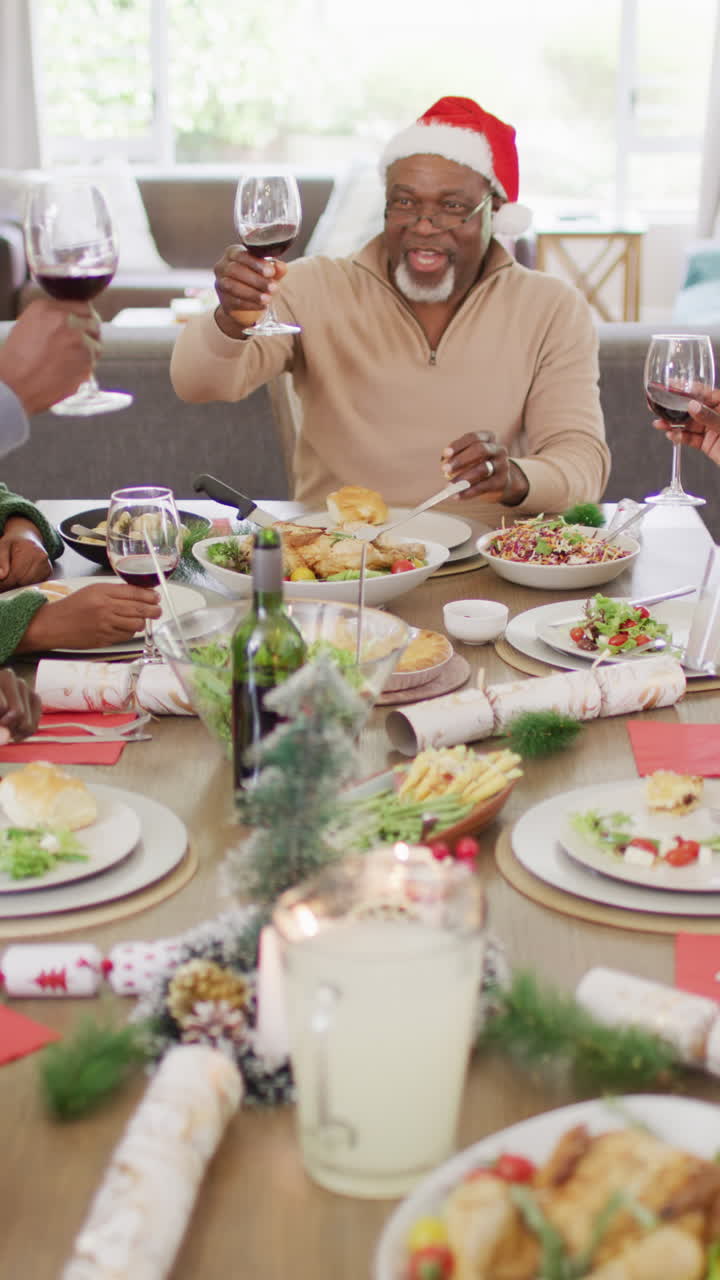 video vertical de una feliz familia afroamericana teniendo una cena de navidad