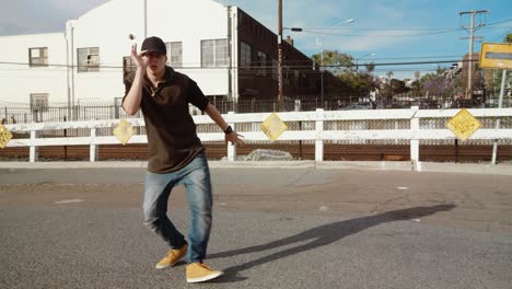 man hip hop dancing outside in street on sunny day