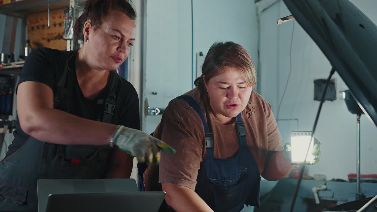 Women Mechanics Inspecting a Car in a Garage
