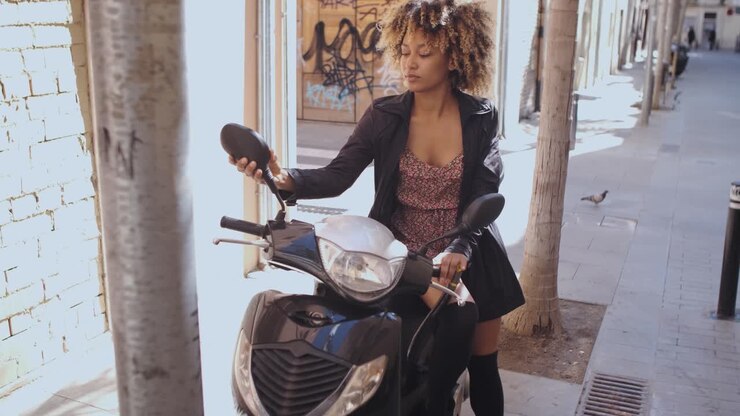 selbstbewusste trendige frau auf roller auf der straße