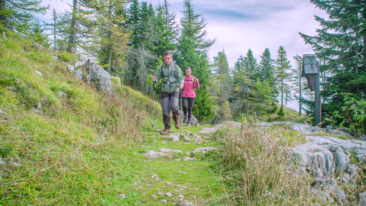 Jonge Kaukasische man en vrouw wandelen over de berg Urslja bij Slovenj Gradec