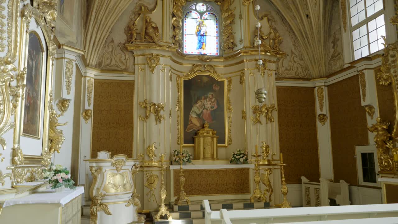 Richly decorated interior of a historic castle chapel with an altar at the center