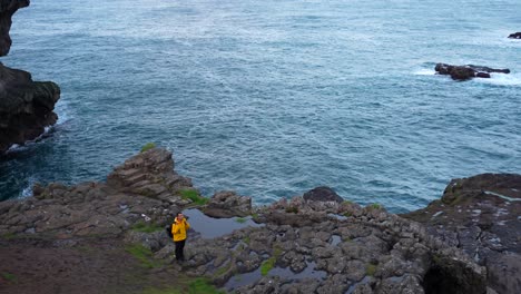 hombre con mochila en la costa atlántica al atardecer en gjogv, islas feroe