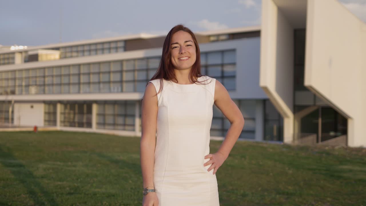 hermosa joven vestida con un vestido blanco posando durante la puesta de sol.