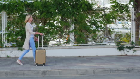 young woman with suitcase on the road wheels are on the pavement concept - arrival to the hotel or v