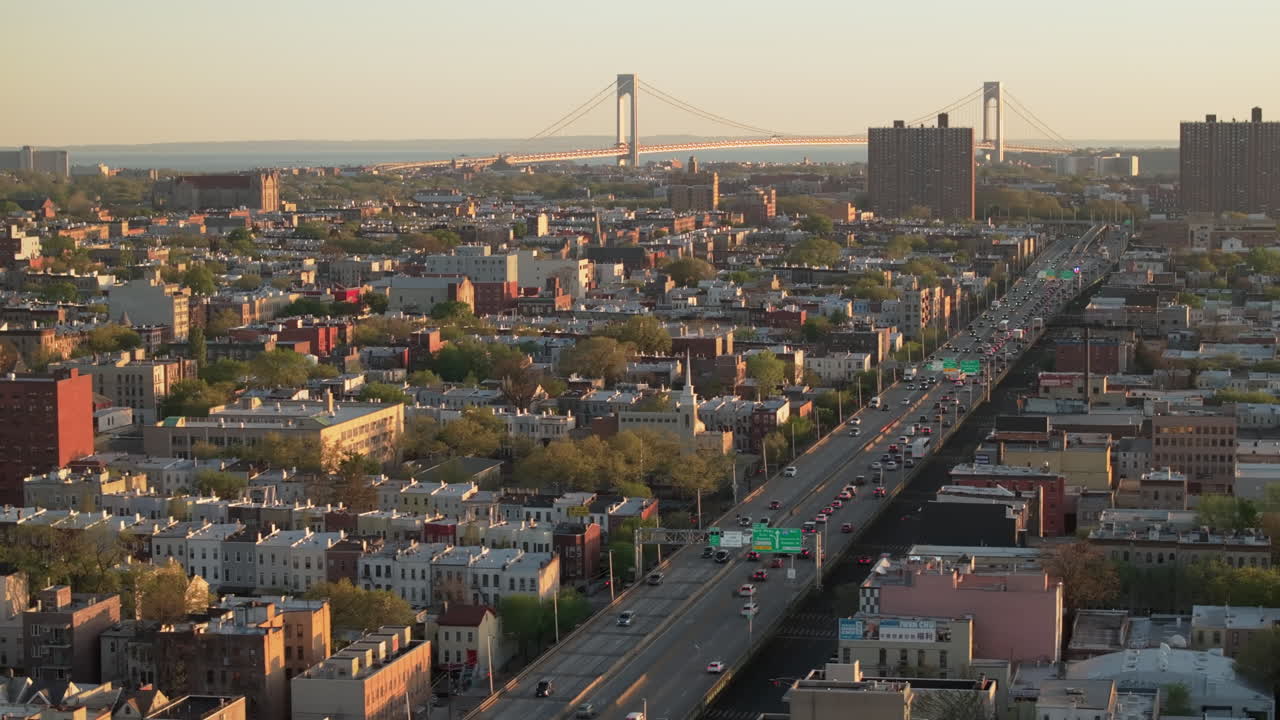 Aerial view of rush hour traffic on Brooklyn's Belt Parkway. Shot at sunset in Bay Ridge with the Verrazzano Bridge in the background.
