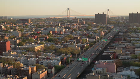 aerial view of rush hour traffic on brooklyn's belt parkway. shot at sunset in bay ridge with the verrazzano bridge in the background.