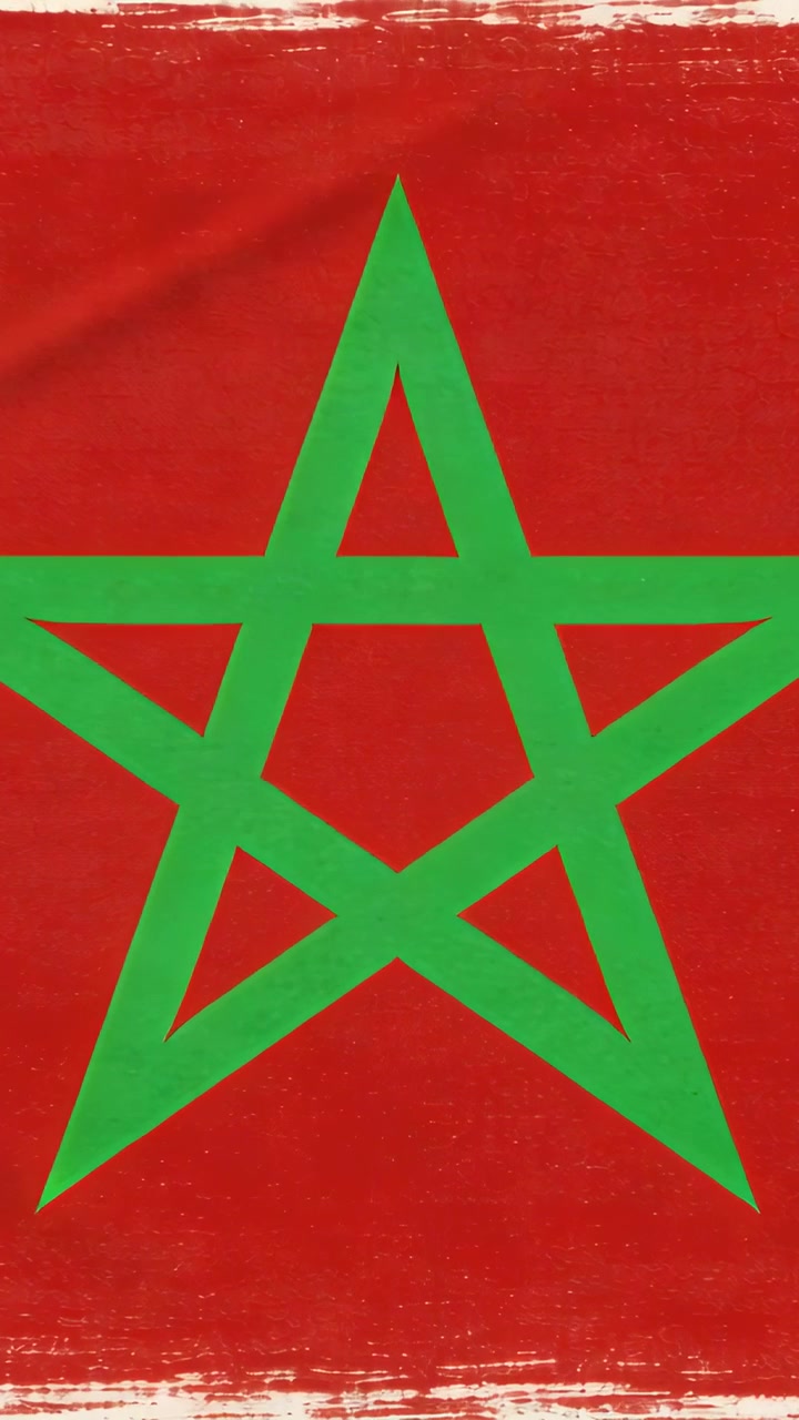 Video verticale: Bandiera rossa con stella verde che sventola in primo piano, mossa dal vento, con bande bianche visibili.