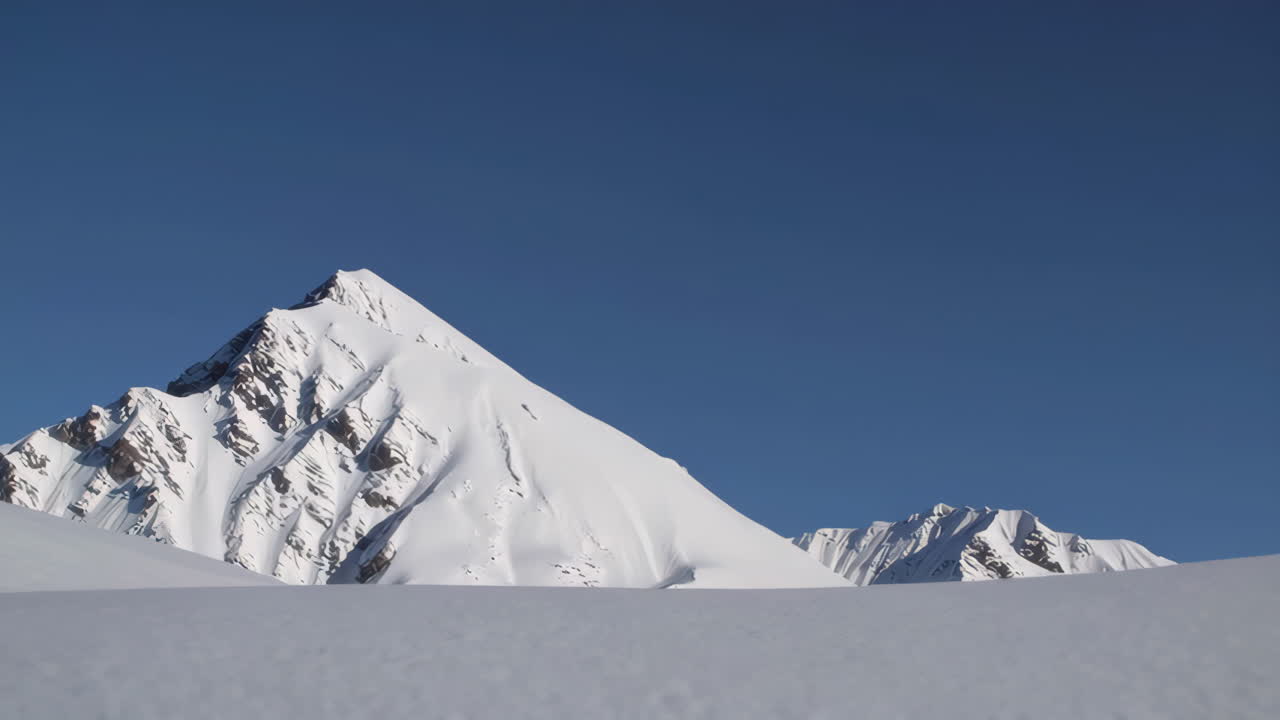 Snow-Capped Mountain Peaks Under a Clear Blue Sky