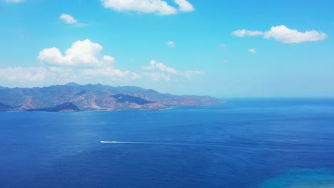 Luxury-boats-sailing-between-the-island-with-mountains-and-white-sandy-beach-on-the-other-island