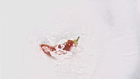 chili falling into water in super slow motion