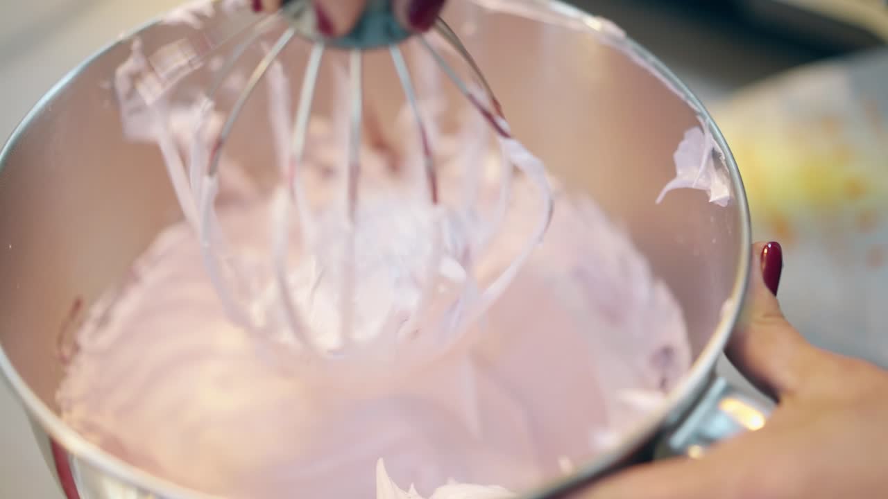 tigela de cromo com mistura misturada rosa e batedor dentro